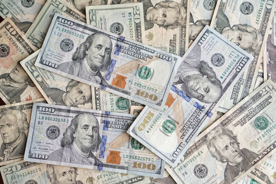 A close-up view of scattered US dollar bills showcasing various denominations and presidents.