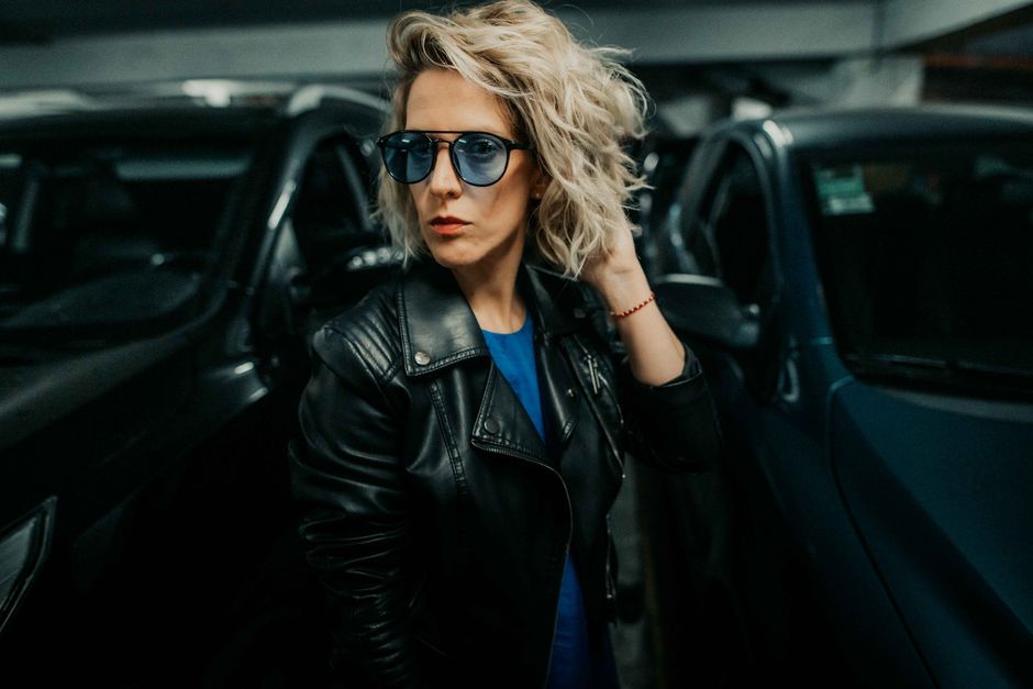 Stylish woman with sunglasses and leather jacket posing in a parking garage, Buenos Aires.