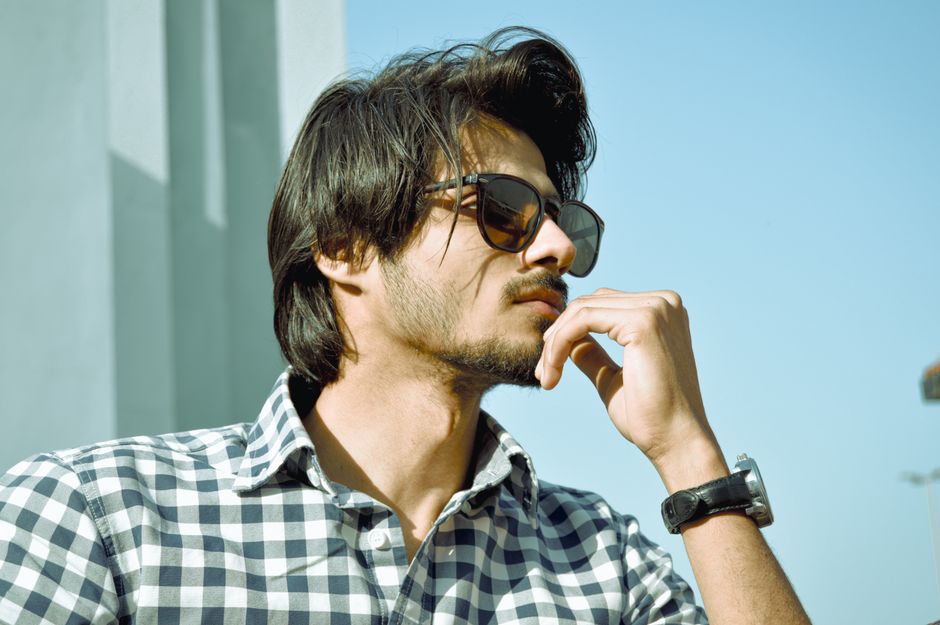 Casual portrait of a thoughtful man in sunglasses enjoying sunny day.
