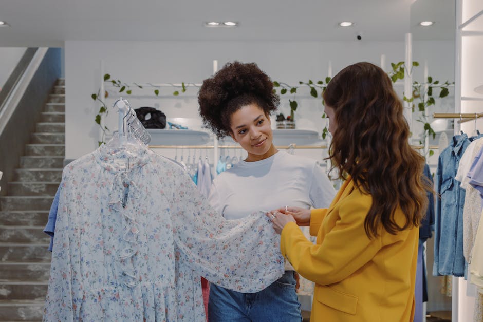 Two women exploring floral dresses in a trendy boutique setting, enjoying a shopping experience.