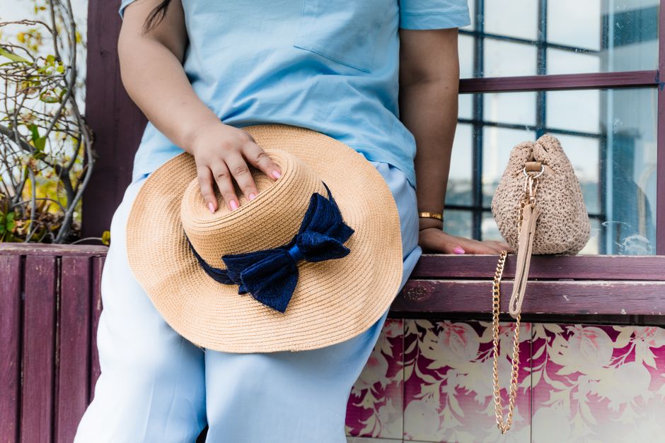 Casual summer moment with straw hat and bag by a window in Baku, Azerbaijan.